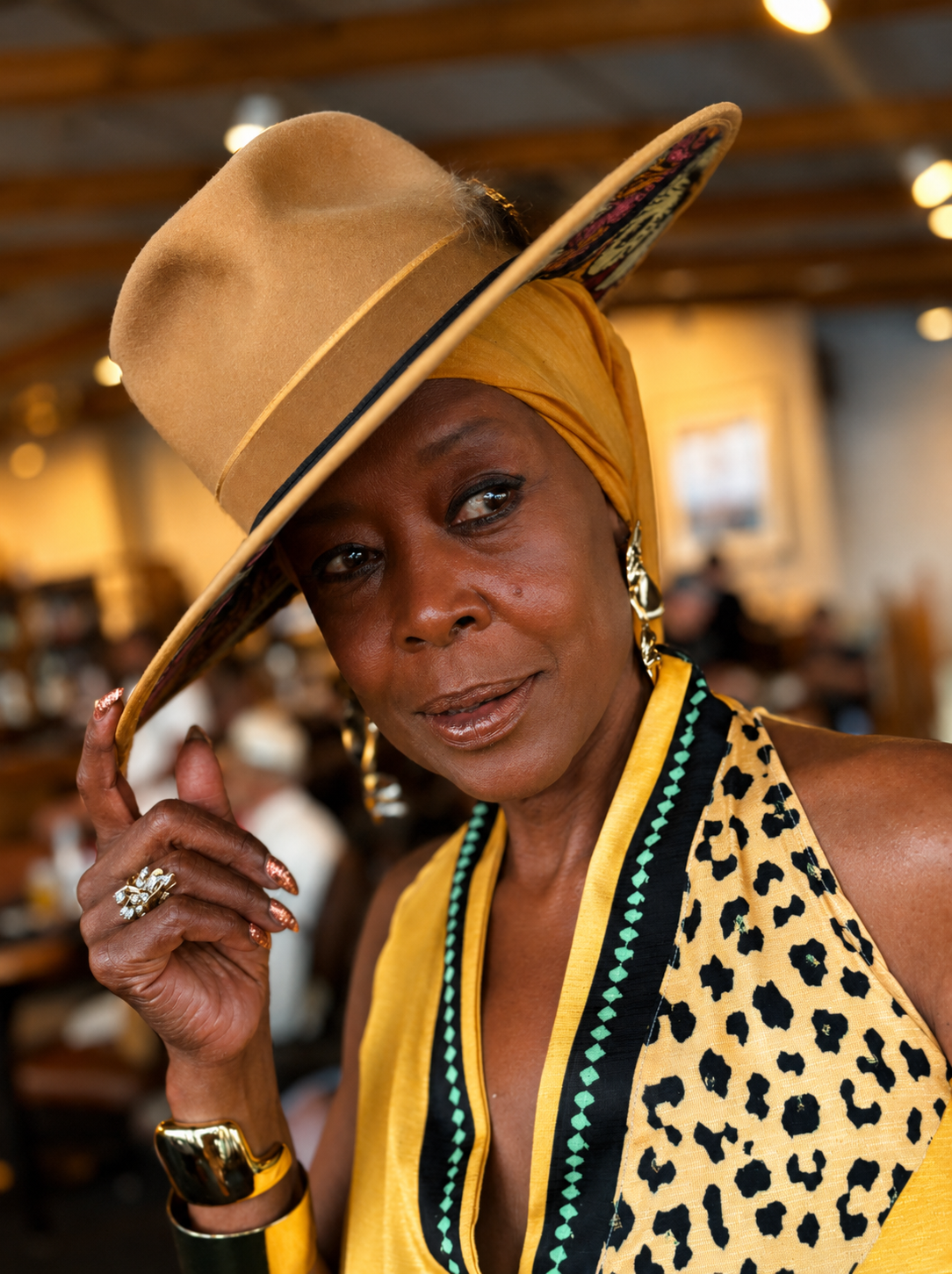 Client tipping the brim of a tan Kerry Kouture fedora, painted owl underbrim showing
