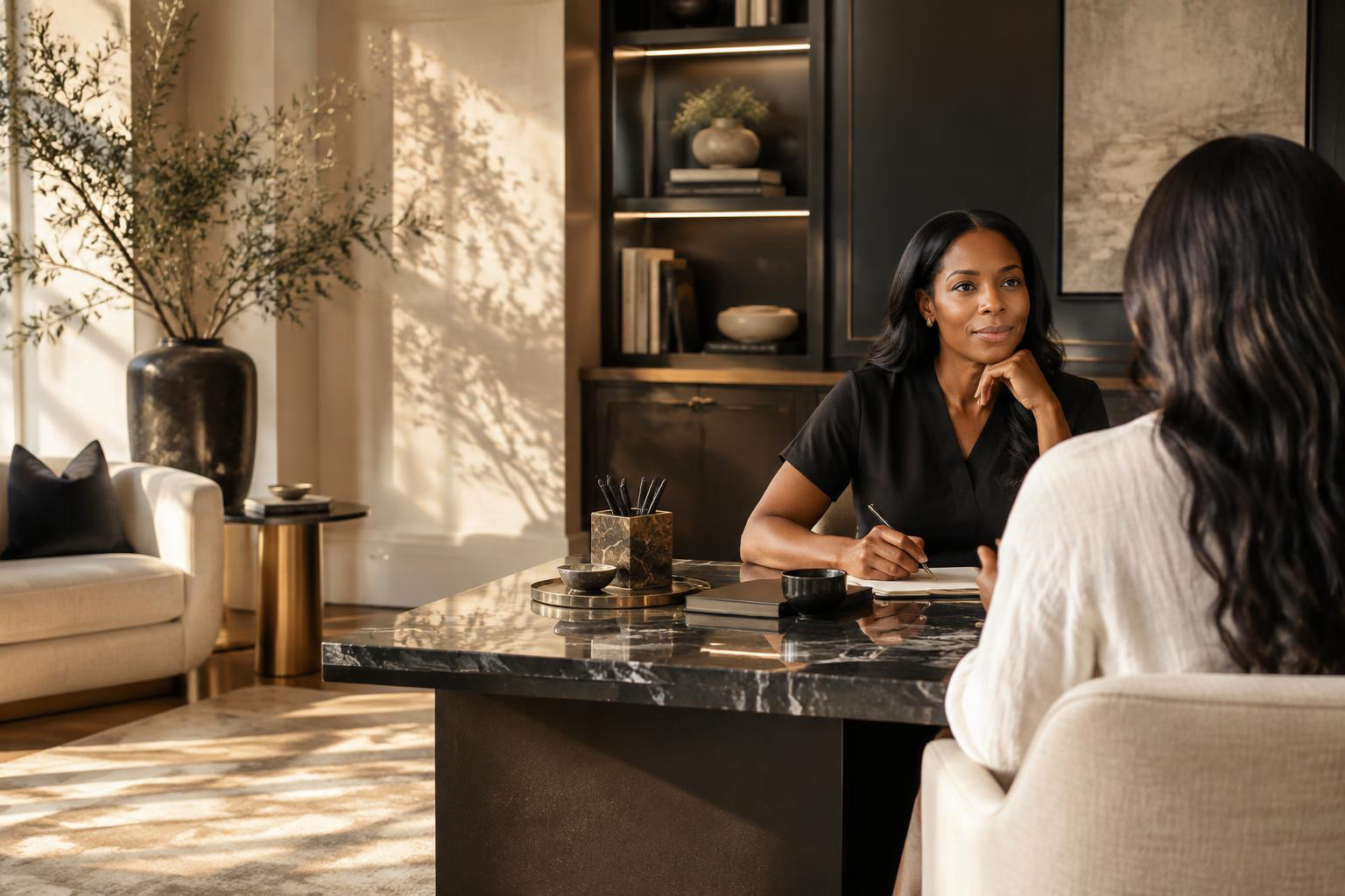 A Black woman clinician in conversation with a client in a sunlit wellness setting